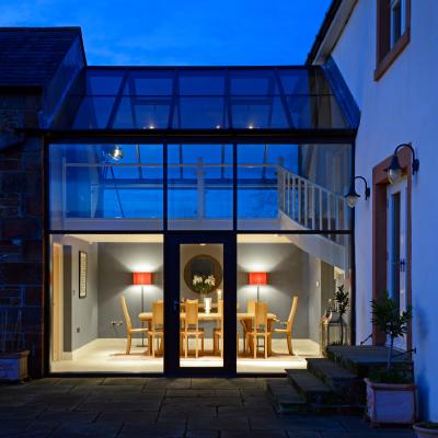 The atrium at dusk with bespoke dining table and Blagr chairs